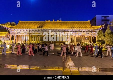 ZHANGYE, CHINA - 22. AUGUST 2018: Abendansicht von Menschen, die in Zhangye, Provinz Gansu, China Tai Chi praktizieren Stockfoto