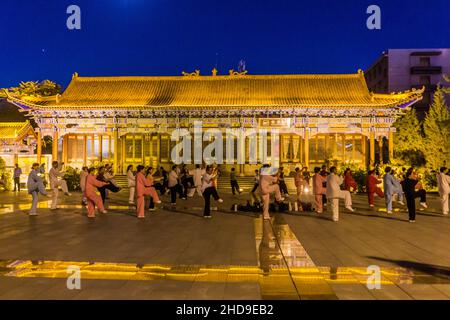 ZHANGYE, CHINA - 22. AUGUST 2018: Abendansicht von Menschen, die in Zhangye, Provinz Gansu, China Tai Chi praktizieren Stockfoto