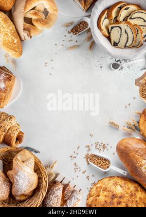 Hausgemachte, frisch gebackene Backwaren auf einem ausgefranster Hintergrund von oben mit Brötchen, Croissant-Brezel mit Puderzucker auf der Oberseite Stockfoto