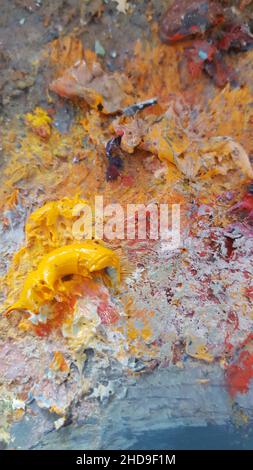 Vertikale Aufnahme der bunten Ölfarben eines Künstlers auf einer Palette Stockfoto
