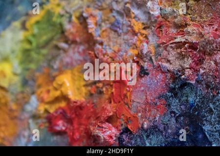 Selektive Fokusaufnahme der Regenbogen-Ölfarben eines Künstlers auf einer Palette Stockfoto