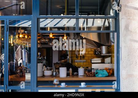 Blick auf das Straßencafe-Interieur vom großen Schaufenster aus Glas Stockfoto