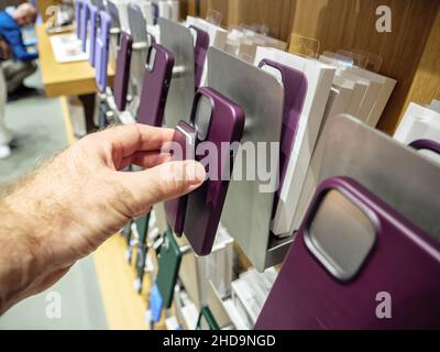 POV männliche Hand hält iPhone Leder Geldbörse mit MagSafe über Fall Stockfoto