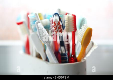 Eine Auswahl an bunten Zahnbürsten aus Kunststoff in einem Topf in einem Badezimmer in Chichester, West Sussex, Großbritannien. Stockfoto