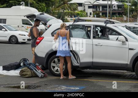 Airlie Beach, Queensland, Australien - Januar 2022: Urlauber laden ihre Ausrüstung nach einem Tag am Strand in ihr Auto Stockfoto