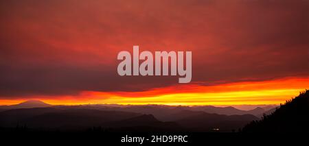 WA19990-00...WASHINGTON - Rollende Grate zum Mount St. Helens vom Mount Adam's High Camp aus betrachtet, als die Sonne durch Rauchwolken untergeht. Stockfoto