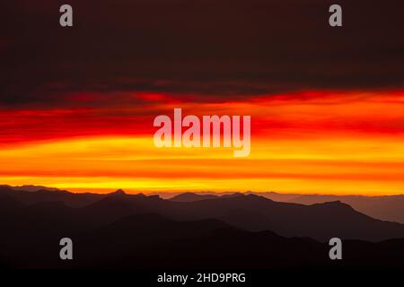 WA19991-00...WASHINGTON - Rollende Grate vom Mount Adam's High Camp aus betrachtet, während die Sonne durch Rauchwolken untergeht. Stockfoto