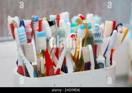 Eine Auswahl an bunten Zahnbürsten aus Kunststoff in einem Topf in einem Badezimmer in Chichester, West Sussex, Großbritannien. Stockfoto