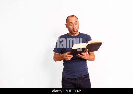 Der Mensch liest ein Buch konzentriert und Ausdruck auf seinem Gesicht, isoliert auf weißem Hintergrund. Stockfoto