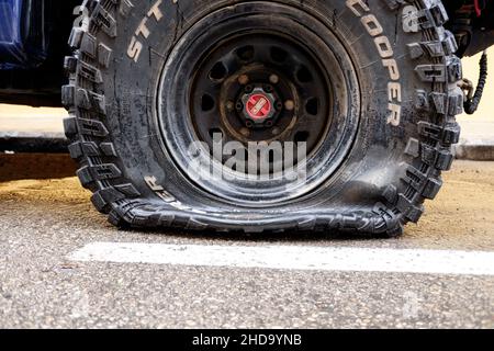 Valencia, Spanien - 15. April 2021: Reifenpanne eines Offroad-Autos, der auf einer Straße geparkt ist. Stockfoto