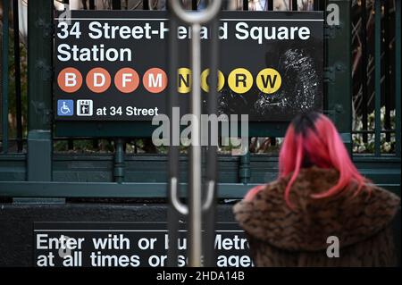 New York, USA. 04th Januar 2022. Eine Frau wird beim Betreten der Station 34th Street Herald Square gesehen, da die MTA (Metropolitan Transportation Authority) die B-, W- und Z-Linien aufgrund des Anstiegs der COVID-19-Infektionen, die durch die Omicron-Variante angeheizt wurden, ausgesetzt hat., New York, NY, 4. Januar 2022. Außerdem wurden weitere Änderungen im Service vorgenommen, da aufgrund von COIVD-19 ein Mangel an Transitbesatzungen gemeldet wird. (Foto von Anthony Behar/Sipa USA) Quelle: SIPA USA/Alamy Live News Stockfoto