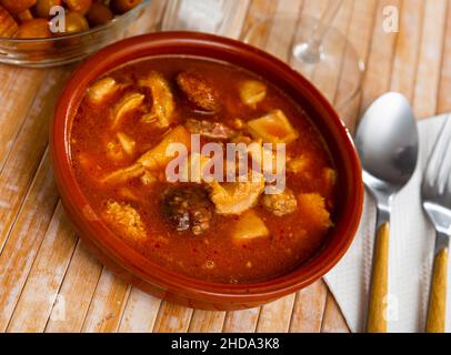 Callos a la Madrilena serviert auf einem Holztisch Stockfoto