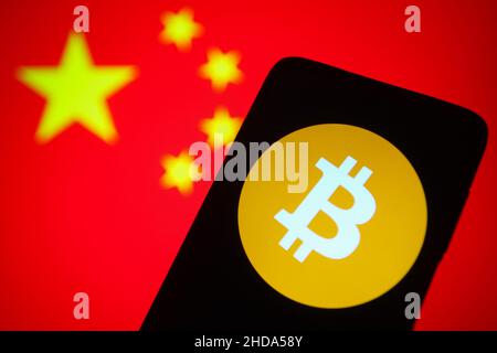 Ukraine. 04th Januar 2022. In dieser Abbildung ist ein Bitcoin-Kryptowährung-Logo auf einem Smartphone-Bildschirm und einer chinesischen Flagge im Hintergrund zu sehen. Kredit: SOPA Images Limited/Alamy Live Nachrichten Stockfoto