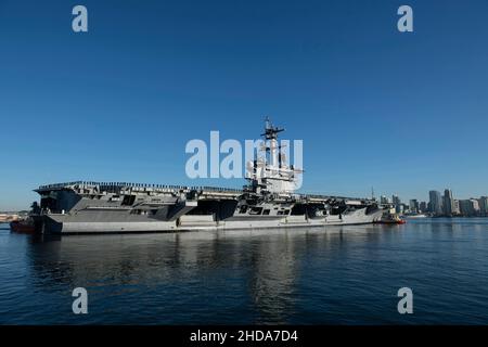 Der Flugzeugträger USS Abraham Lincoln (CVN 72) der Nimitz-Klasse umstellt die San Diego Bay in San Diego, Kalifornien, für einen planmäßigen Einsatz am 3. Januar 2022. Die Abraham Lincoln Carrier Strike Group besteht aus Carrier Strike Group 3, USS Abraham Lincoln (CVN 72), Carrier Air Wing (CVW) 9, Destroyer Squadron 21, dem Ticonderoga-Klasse Lenkraketen-Kreuzer USS Mobile Bay (CG 53), Und die Arleigh Burke-Klasse mit Lenkraketen USS Fitzgerald (DDG 62), USS Gridley (DDG 101), USS Sampson (DDG 102) und USS Spruance (DDG 111). Abraham Lincolns eingeschiffter Luftflügel besteht aus der „Wallba Stockfoto