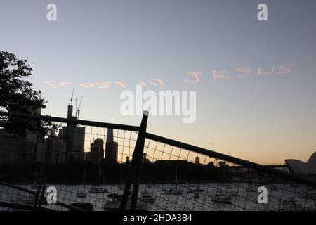 „Vertrauen in Jesus“, geschrieben am Himmel über Sydney, Australien, am Silvesterabend. Blick vom Mrs Macquaries Point im Royal Botanic Garden Sydney. Stockfoto