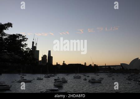 „Vertrauen in Jesus“, geschrieben am Himmel über Sydney, Australien, am Silvesterabend. Blick vom Mrs Macquaries Point im Royal Botanic Garden Sydney. Stockfoto