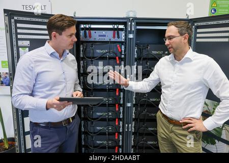 PRODUKTION - 18. November 2021, Sachsen-Anhalt, Wittenberg: Die TESVOLT-Gründer und Geschäftsführer Simon Schandert (l.) und Daniel Hannemann stehen in ihrem Unternehmen vor einem Batteriespeicher. TESVOLT entwickelt und baut Batteriespeichersysteme für Handel und Industrie. Die Lithium-Energiespeicher auf Nickel-Mangan-Kobalt-Oxid-Basis können mit allen regenerativen Energiequellen kombiniert werden, einschließlich eines Blockheizkraftwerks oder einer Brennstoffzelle. Nach eigenen Angaben hat das Unternehmen weltweit bereits mehr als 2200 Speicherprojekte realisiert. (Zur dpa 'Wittenberg-Technologie Stockfoto