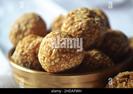 Nahaufnahme eines gezackelten Sesams/Til Laddu/Laddoo in einem Messinggerät/urli/Makar Sankranti/Indien Stockfoto