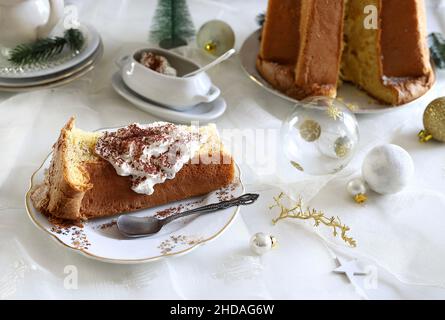 Traditionelle italienische Weihnachts-Pandoro-Scheibe mit Creme. Weihnachts- und Neujahrstraditionen Konzept. Stockfoto