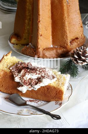 Traditionelle italienische Weihnachts-Pandoro-Scheibe mit Creme. Weihnachts- und Neujahrstraditionen Konzept. Stockfoto