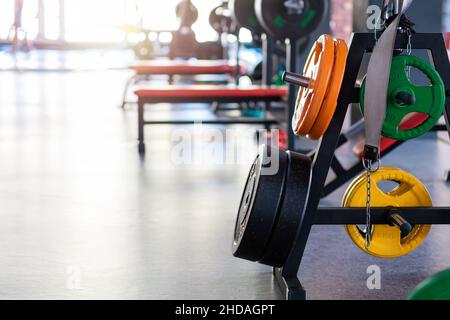 Nahaufnahme von bunten Hantelscheiben an der Bar des Fitnessstudios. Speicherplatz kopieren. Konzept von Bodybuilding und Fitness. Stockfoto