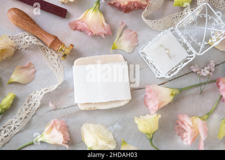 Seifenstück auf einem Marmortisch mit rosa Blumen, Geschenkbox mit Perlenring und Vintage-Bändern, Draufsicht. Seifenmockup Stockfoto