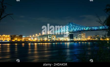 Blick auf die Skyline von Montreal, die Molson-Fabrik und die Jacques Cartier-Brücke bei Nacht von der Insel St. Helen Stockfoto