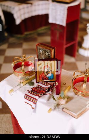 Tisch mit Kronen, Kerzen, der Ikone der Gottesmutter und der Bibel in der Kirche St. Sava in Tivat Stockfoto