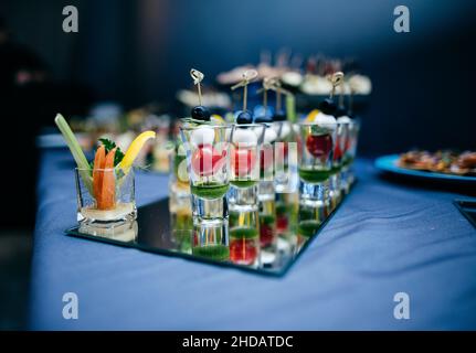 Leichte Snacks auf einem Teller auf einem Buffettisch. Verschiedene Mini-Kanapees Stockfoto