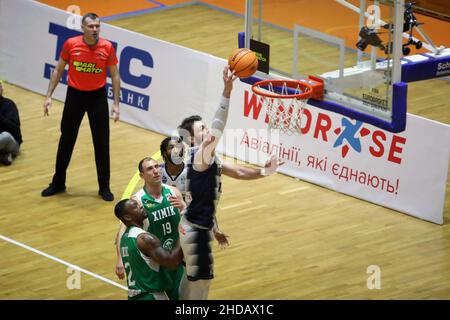 KHARKIV, UKRAINE - 4. JANUAR 2022 - Spieler von BC Kharkivski Sokoly (weißes Kit) und BC Khimik (grünes Kit) werden während der ukrainischen Bas in Aktion gesehen Stockfoto