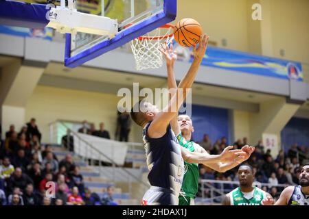 KHARKIV, UKRAINE - 4. JANUAR 2022 - Spieler von BC Kharkivski Sokoly (weißes Kit) und BC Khimik (grünes Kit) werden während der ukrainischen Bas in Aktion gesehen Stockfoto