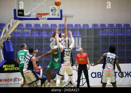 KHARKIV, UKRAINE - 4. JANUAR 2022 - Spieler von BC Kharkivski Sokoly (weißes Kit) und BC Khimik (grünes Kit) werden während der ukrainischen Bas in Aktion gesehen Stockfoto