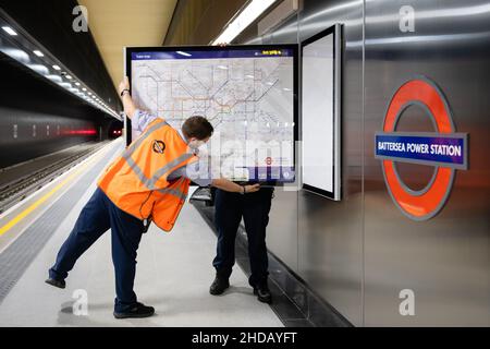 Mitarbeiter der Londoner U-Bahn installieren vor der Eröffnung am Montag, den 20th. September 2021, neue Karten für Züge und U-Bahnen im Battersea Power Station Stockfoto