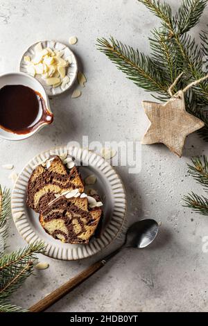 Zwei Scheiben Zebrakuchen auf einem Teller, Draufsicht, weihnachtskomposition mit Tannenzweigen Stockfoto