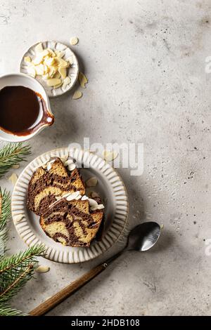 Zwei Scheiben Zebrakuchen auf einem Teller, Draufsicht, weihnachtskomposition mit Tannenzweigen Stockfoto