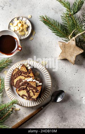 Zwei Scheiben Zebrakuchen auf einem Teller, Draufsicht, weihnachtskomposition mit Tannenzweigen Stockfoto