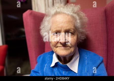 Ein älteres Paar in den Achtzigern sitzt zusammen in ihrem Pflegeheim, England, Vereinigtes Königreich Stockfoto