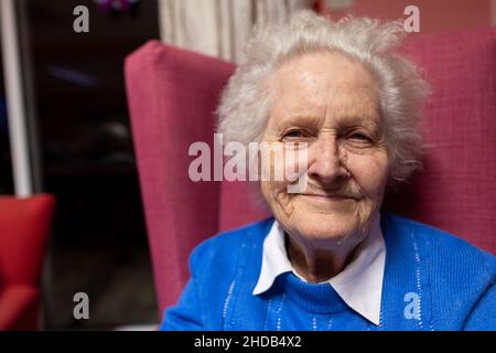 Ein älteres Paar in den Achtzigern sitzt zusammen in ihrem Pflegeheim, England, Vereinigtes Königreich Stockfoto