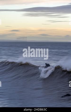Surfer auf Surfbrett reiten eine Welle in saltburn, North yorkshire, großbritannien Stockfoto