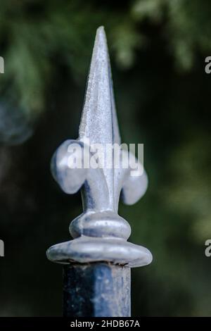 Stählerne Straßenmauer mit dekorativen Stacheln. Stockfoto