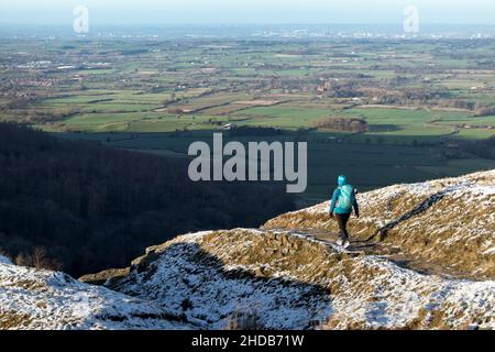 Walker auf dem Cleveland Way in Urra Moor im Winter mit Blick auf Teesside, North Yorkshire Moors National Park, Großbritannien Stockfoto