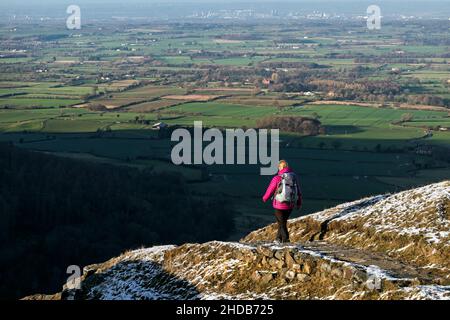 Walker auf dem Cleveland Way in Urra Moor im Winter mit Blick auf Teesside, North Yorkshire Moors National Park, Großbritannien Stockfoto