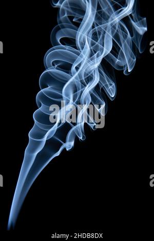 Hübsche Muster von Rauchspuren aus Weihrauch auf schwarzem Hintergrund Stockfoto