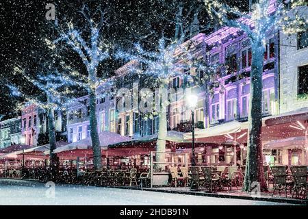 Bars und Restaurants mit weihnachtsbeleuchtung auf dem berühmten Vrijthof in Maastricht während des Schneefalls, Niederlande Stockfoto