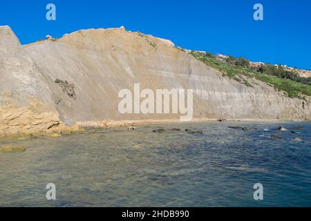 Steile blaue Lehmhänge, mit Schutt, der Geröll bildet, an der Küste bei Xatt l-Ahmar, Ghajnsielem, Gozo Stockfoto