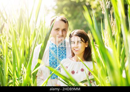 Junges Paar in ukrainischen Hemden auf einem Feld mit Mais Stockfoto