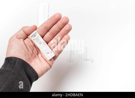 Kaukasische Männerhand, die einen schnellen Antigen-Test auf weißem Hintergrund zeigt. Covid-19-Konzept Stockfoto