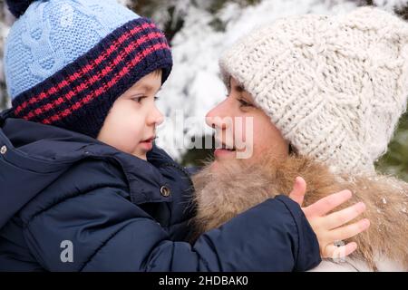 Mutter und Sohn schauen sich im Winterwald, im Familienvertreib, im Urlaub an Stockfoto