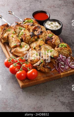 Vorspeise Hähnchen Kebab mit Gemüse Nahaufnahme auf Holzbrett. Vertikal Stockfoto