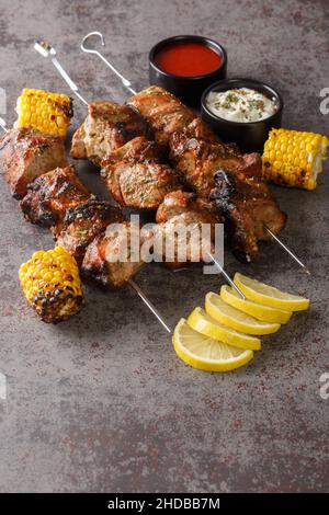 Gegrillte Fleischspieße shish Kebab close-up auf einem grauen Beton Hintergrund. Vertikal Stockfoto